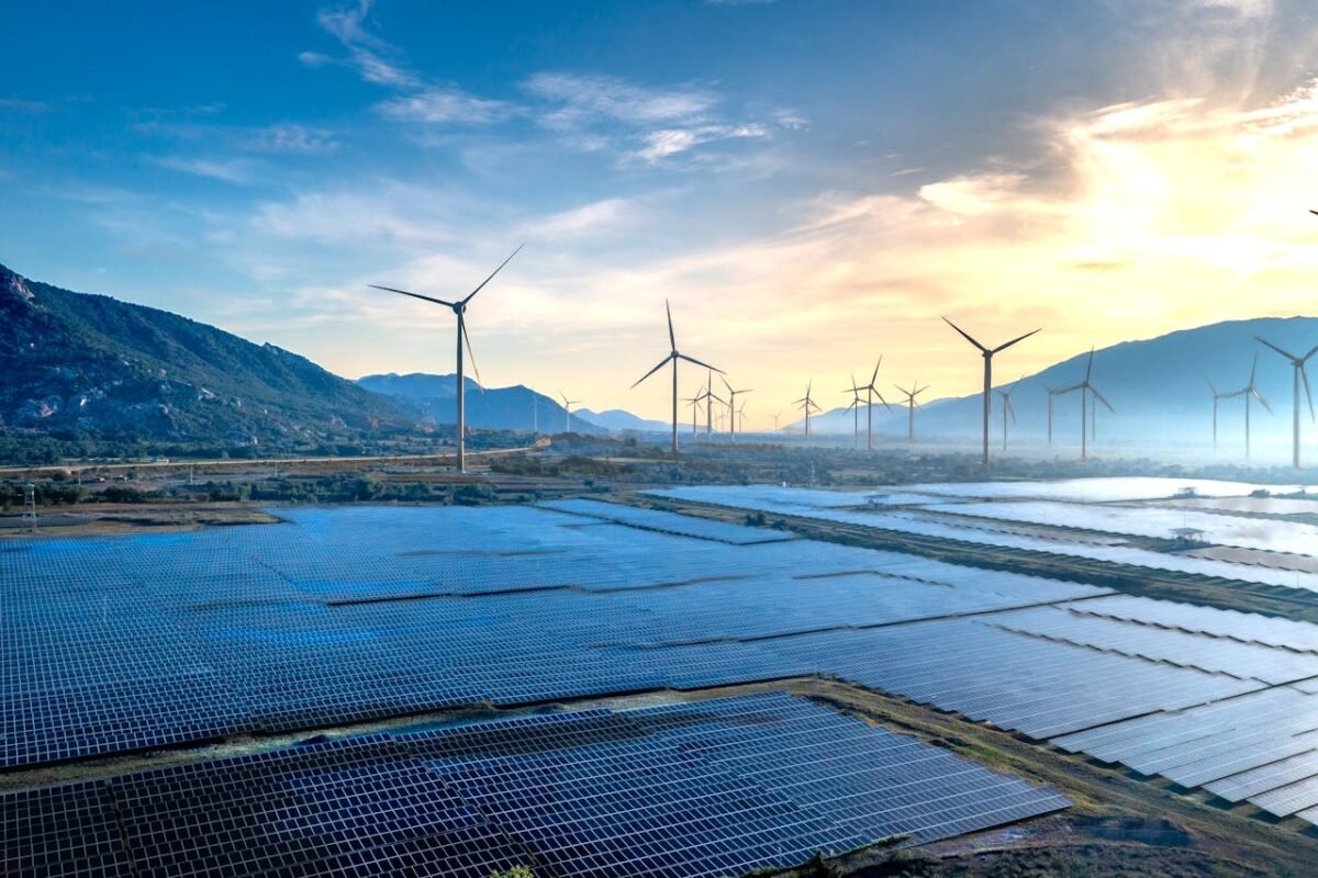 Stunning landscape featuring solar panels and wind turbines at sunrise, symbolizing sustainable energy.